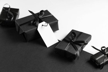 Renk arkaplanında boş kağıt etiketli hediye kutuları. Kara Cuma indirimi