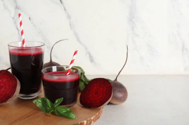 Beyaz arka planda fesleğenli ve sebzeli taze pancar suyu.