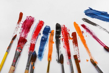 Gri arkaplanda boya darbeleri olan sanatçı fırçaları