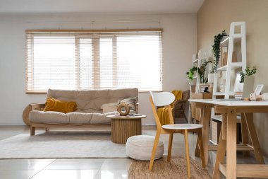 Programcının iş yeri, kanepesi ve raf üniteleri olan oturma odasının içinde.