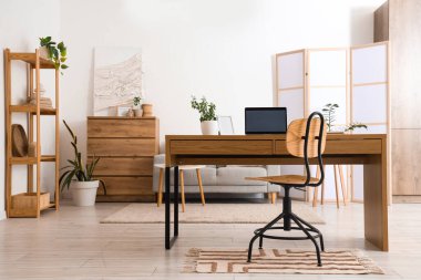 Programcının iş yeri, katlanan ekran ve bitkilerle aydınlık oturma odasının içi