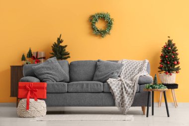 Oturma odasında rahat bir kanepe ve Noel ökseotu çelengi var.