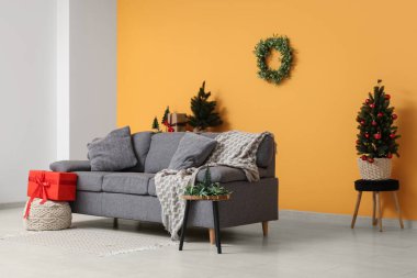 Rahat kanepesi ve Noel ökseotu çelengi olan şık bir oturma odası.