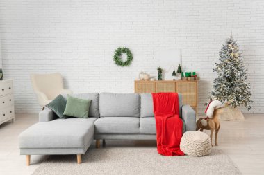Kırmızı ekose, ahşap rengeyiği ve Noel 'de oturma odasının içinde ökseotu çelengi olan rahat bir kanepe.
