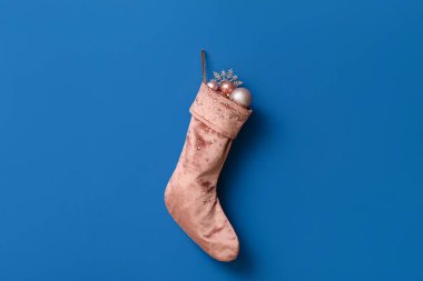 Mavi duvarda taşaklı ve kar taneli Noel çorapları asılı