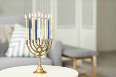 Evdeki masada mum yakan Menorah, yakın plan. Hanuka kutlaması