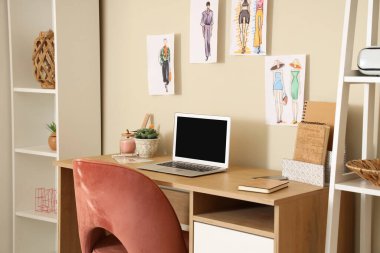 Boş dizüstü bilgisayarı ve odada çizimleri olan işyeri