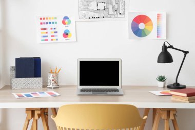 Işık odasında boş dizüstü bilgisayarı olan işyeri