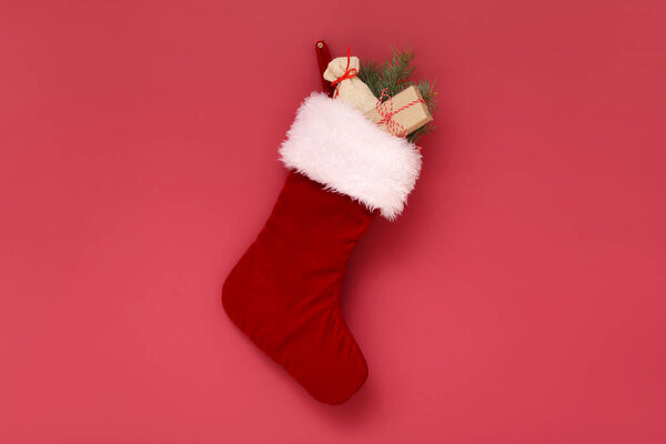 Рождественский носок с веткой из мешка и елки, висящей на красной стене