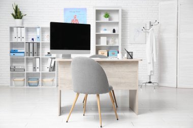 Doktorun çalışma yeri ve raf üniteleri olan bir tıp bürosu.