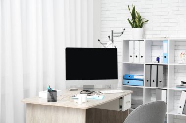 Ofisinde boş bilgisayar monitörü ve tıbbi gereçleri olan doktorun işyeri.