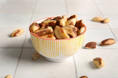 Beyaz fayanslı lezzetli Brezilya fındıkları olan kase.