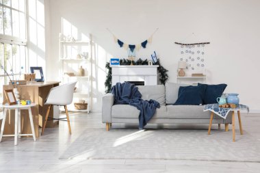 Interior of festive living room with grey sofa and decorations for Hanukkah celebration clipart