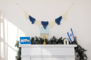 Mantelpiece with menorah, greeting card, flag of Israel and garland. Hanukkah celebration clipart