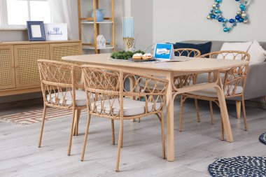 Hanuka kutlaması için yemek masası ve süslemeleri olan şenlikli bir oturma odası.