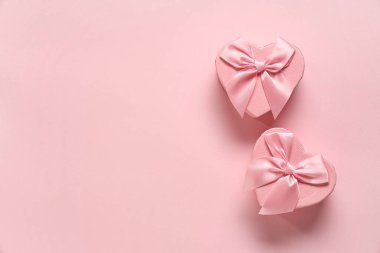 Pembe arka planda kalp şeklinde hediye kutuları. Sevgililer Günü kutlaması