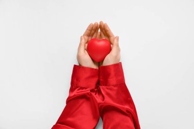 Beyaz arka planda kırmızı kalpli bir kadın eli. Sevgililer Günü kutlaması