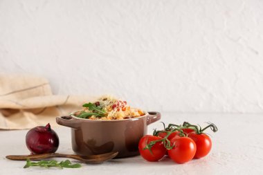 Bowl of pasta fagioli with cheese, arugula and tomatoes on white background clipart