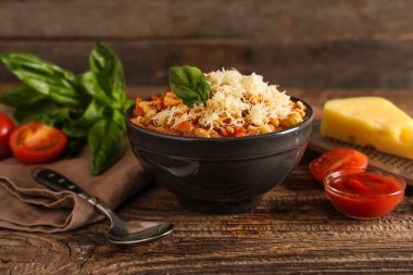 Tahta arka planda peynirli ve fesleğenli makarna.