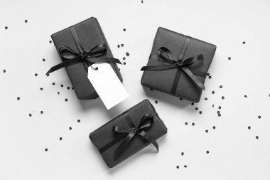 Gri arka planda siyah hediye kutuları ve konfeti