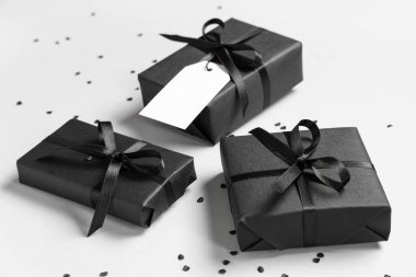 Gri arka planda siyah hediye kutuları ve konfeti
