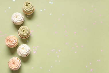 Tatlı doğum günü kekleri ve yeşil arka planda konfeti.