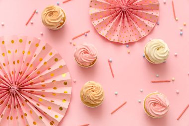 Tatlı doğumgünü kekleri ve pembe arka planda mumlar.