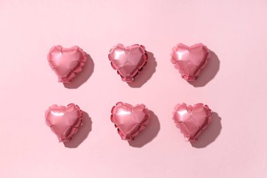 Pembe arka planda kalp şeklinde hava balonları. Sevgililer Günü kutlaması