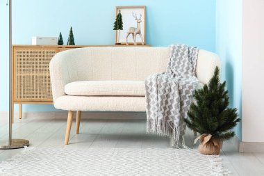 Beyaz kanepeli ve Noel dekorlu festival salonu.