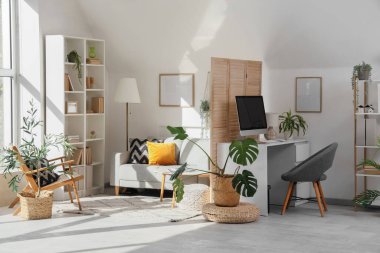 Çalışma alanı, katlama ekranı ve bitkileri olan ofis içi