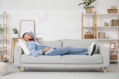 Genç adam izin gününde evde dinleniyor.