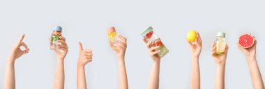 Işık arka planında farklı aşılanmış suyu tutan eller.