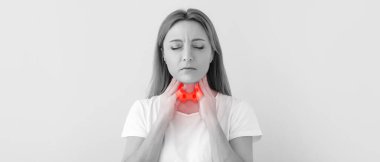 Yetişkin bir kadın arka planda tiroit bezini kontrol ediyor. 