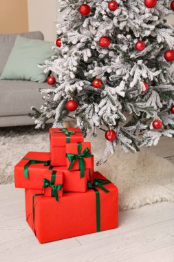 Güzel dekore edilmiş Noel ağacı ve yerde hediyeler