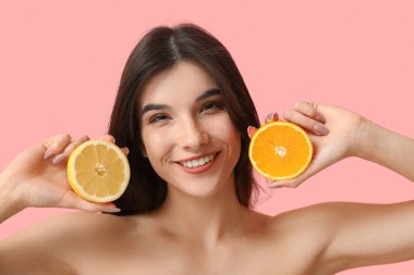 Pembe arka planda turuncu ve limonlu güzel bir kadın.