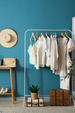Mavi duvarın yanındaki beyaz elbiseli rafta.