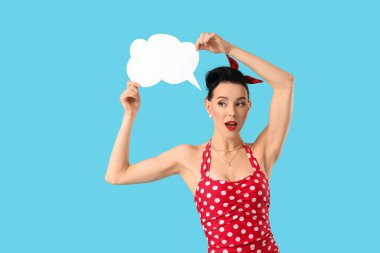 Mavi arka planda boş konuşma balonu olan genç kadın.