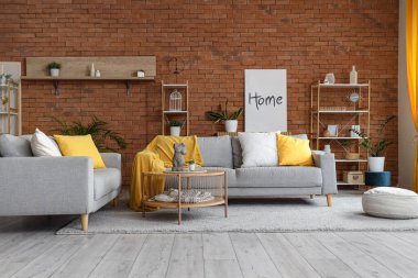 Sıcak kanepeler, taş kadın vücudu olan kahve masası ve oturma odasının içinde puf.