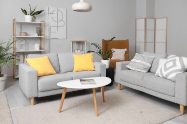 Oturma odasının içinde kanepeler, masa ve koltuk var.