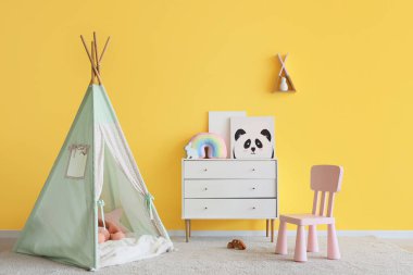 Oyun çadırı, tuvalet ve sandalyeli çocuk odasının içi.