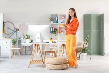 Ofisinde tablet bilgisayarı olan genç bayan grafik tasarımcısı