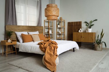 Işıl ışıl yatak odasının içi. Sıcak yatak örtüsü ve ahşap perdeli.