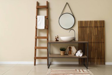 Lavabosu, aynası ve merdiveni olan bir banyo.