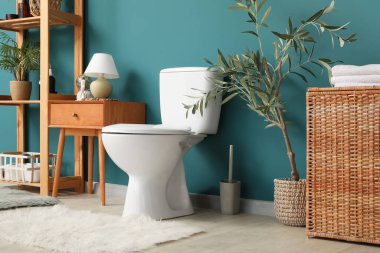 Tuvaleti, masası ve raf ünitesi olan bir tuvalet.