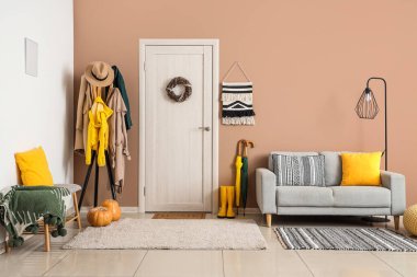 Koridorun içinde kapı, askılık ve kanepe var.