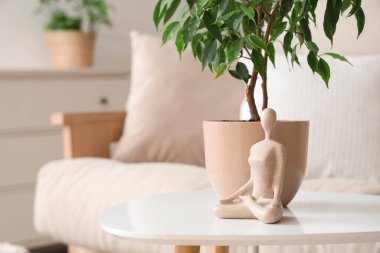 Oturma odasında üzerinde bitki olan heykel, yakın plan.