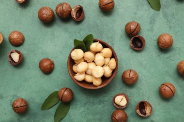 Lezzetli fındıklı ahşap kase ve yeşil arka planda yapraklar.