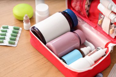 Ahşap masada ilaçlı ilk yardım çantası, yakın plan.