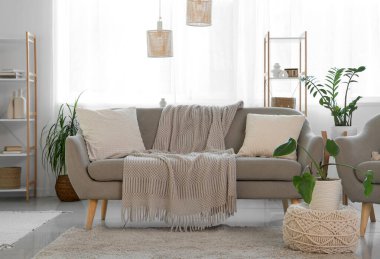 Gri kanepeli, raf üniteli ve pencereli aydınlık oturma odasının içi.