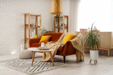 Interior of living room with red sofa, table and shelf units